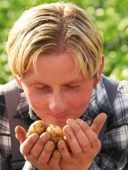 Andreas Faller riecht an den Frühkartoffeln